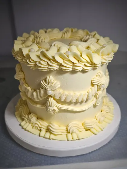 A minimalist take on the vintage style, this cake uses a single color of buttercream to create stunning texture through ruffles, swags, and pearls.