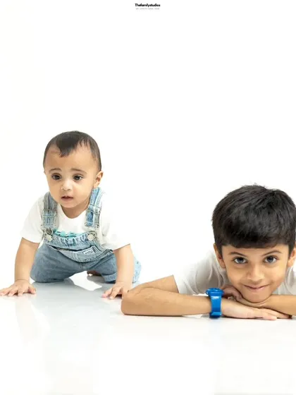 Playful sibling interaction in the studio. This shot captures the fun dynamic between an older brother and his crawling baby brother.