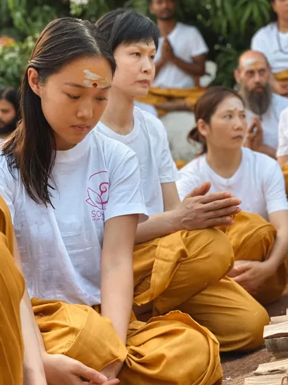 Students from diverse backgrounds sit together in meditation, each on their own journey, yet united in their quest for inner peace. The ashram is a melting pot of cultures with a shared spiritual goal.