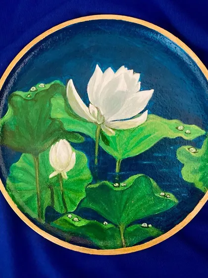 A serene painting of a white lotus on a wooden plate. The deep blue water and glistening dewdrops on the leaves create a sense of tranquility and peace.