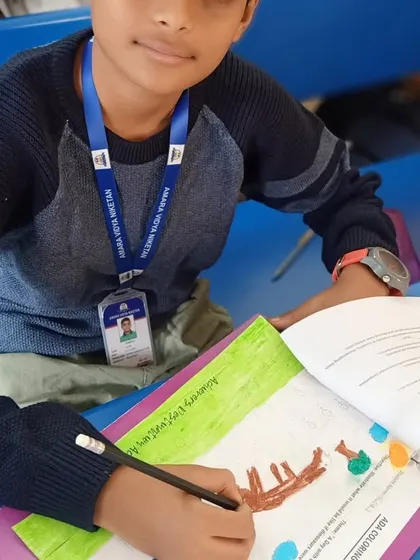 A student proudly displays his colorful artwork. Seeing the satisfaction on a child's face after completing their work is one of the most rewarding parts of what I do.
