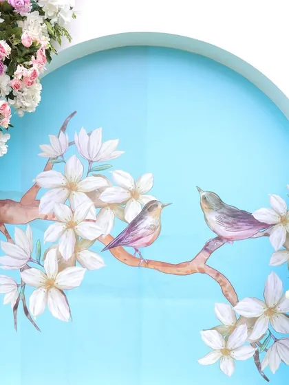 A beautiful detail shot of a painted panel featuring two birds on a branch, adding a touch of soft color to the minimalist theme.