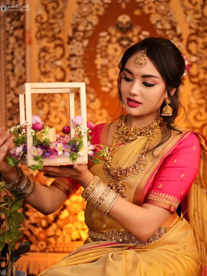 A model in a traditional South Indian look, holding a decorative floral piece. This conceptual portrait is filled with soft light and elegant details, creating a storybook feel.