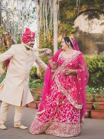 A playful dance between the newlyweds, Arjun and Nerrisa, in their vibrant wedding attire.