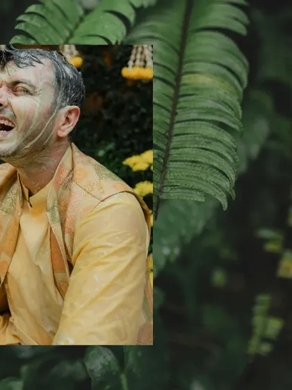 A guest grimaces with laughter as he gets covered in haldi paste, a great candid shot showing the fun isn't just for the couple.