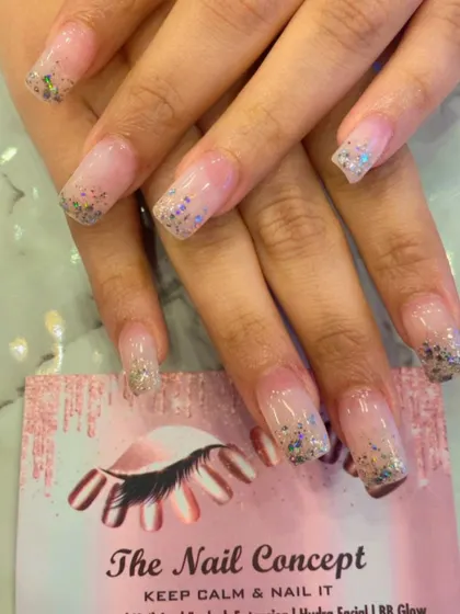 Clear nail extensions in a square shape with a beautiful silver and blue glitter gradient starting from the tips. This creates a lovely, icy effect that is both simple and eye-catching.