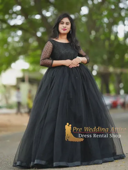 A standing portrait in the black ball gown, showcasing the elegant silhouette and the detailed sheer sleeves.
