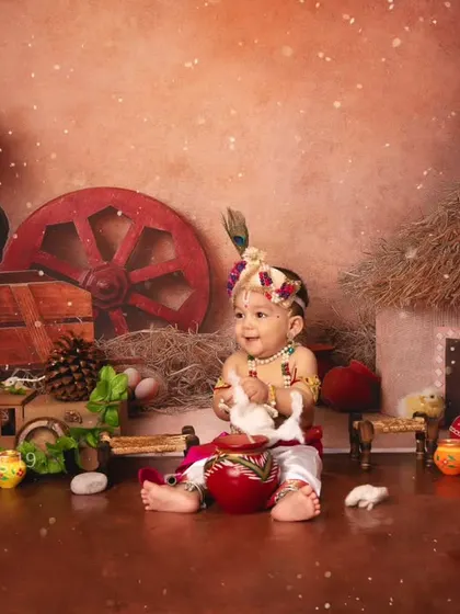 A happy little Krishna enjoying some cotton "makhan" in our rustic village-themed Janmashtami set.