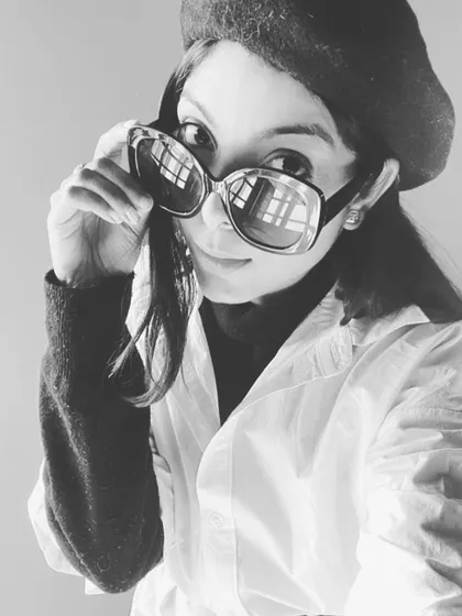 A classic black and white portrait showing off a winter stylist look. A white shirt, beret, and statement sunglasses create a look that is full of drama and style.