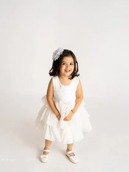 Celebrating three years of joy! This simple and classic portrait with a large number "3" balloon is a great way to mark a toddler's birthday.