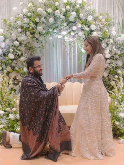 The classic proposal shot. The groom on one knee against a stunning floral backdrop, a timeless and cherished memory.