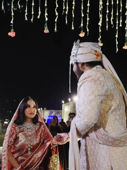 The groom takes his bride's hand, guiding her during the ceremony, a simple yet powerful gesture of partnership.