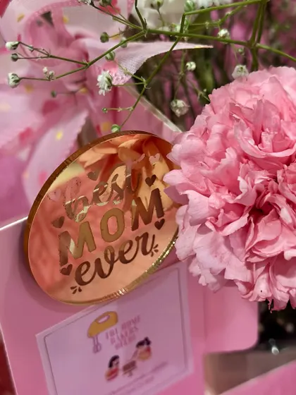 A close-up of the "Best Mom Ever" acrylic tag included in our Mother's Day flower arrangements. These little details make the gift extra special.