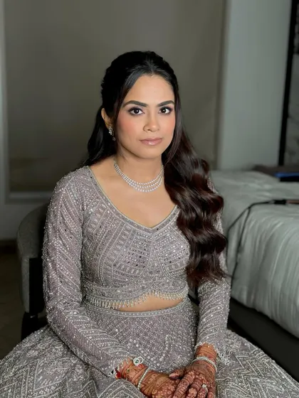 Looking straight at the camera, her confidence shines. The dewy glam is perfect for a Sangeet night, designed to catch the light as she moves.