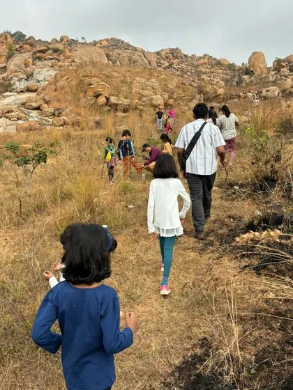 Children and adults walk together along the trail, sharing stories and enjoying the journey during our community trek.