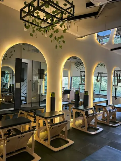 The Pilates chairs and arched mirrors create a unique workout environment. This setup is perfect for targeting specific muscle groups with precision.