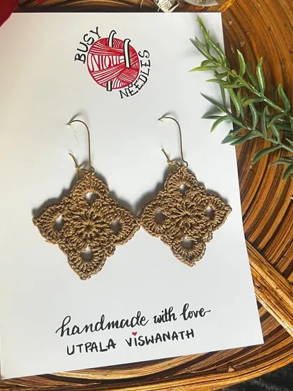 My Diamond Dangler earrings in a warm, earthy brown. They look beautiful against the natural rattan background.