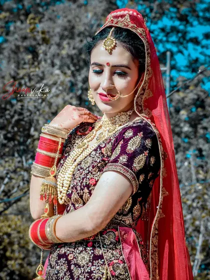 A beautiful outdoor portrait of a bride in a purple velvet lehenga, her smile as bright as the sunny day.