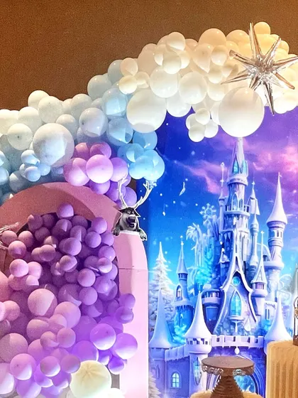 A detailed look at the balloon work and backdrop for our Frozen theme. The cascading purple balloons create a sense of drama, perfectly complementing the icy castle print.
