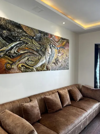 An angled view of the mural, highlighting the metallic and earthy tones used in the painting process.