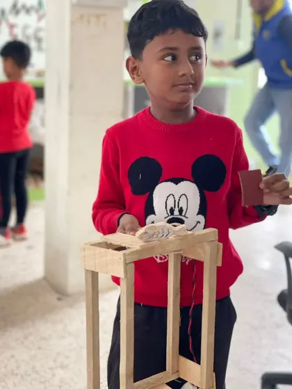 The look of pure pride. This young maker knows he built his wooden lantern from scratch, and that feeling is what inspires future innovation.