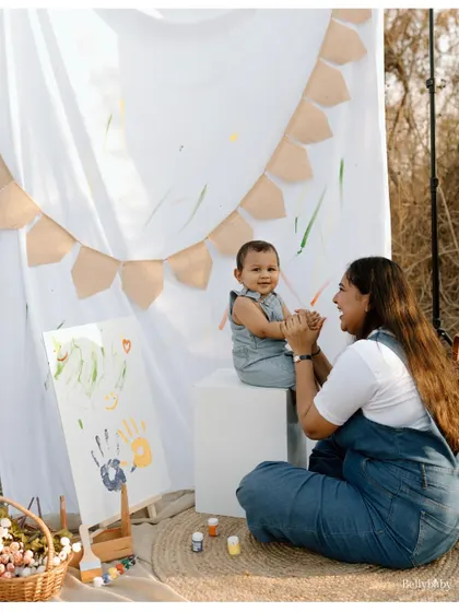 A mother and son sharing a creative moment during their outdoor painting session. It's a memory of connection and shared fun.