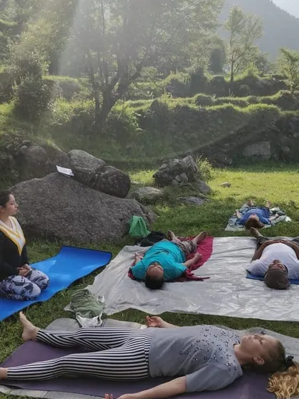 Guiding new students through a relaxing Savasana during an outdoor session in Dharmkot. Even on your first day, you can experience the profound peace that yoga brings.