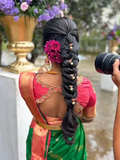 Another angle showcasing the detailed hairstyling and how the saree drape complements the overall bridal ensemble. The rich texture of the silk saree is evident here.