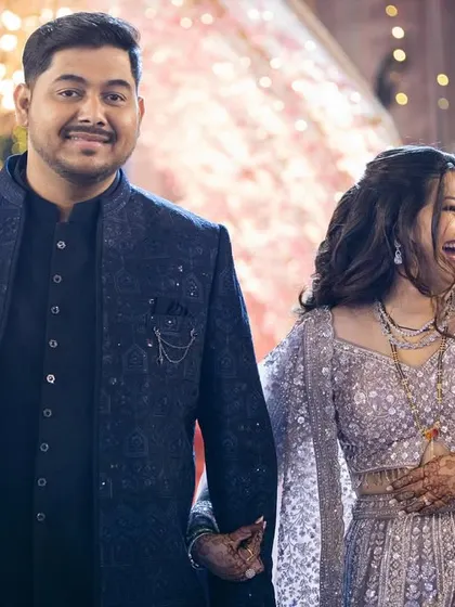 A happy couple at their reception. The bride's makeup is glamorous and joyful, perfect for the celebratory atmosphere.