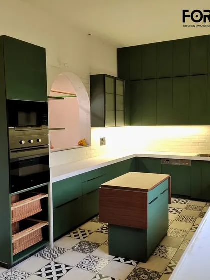 Another view of the matte green U-shaped kitchen, showing the tall unit with an integrated oven and microwave. This layout provides a highly efficient workspace with everything organized and accessible.
