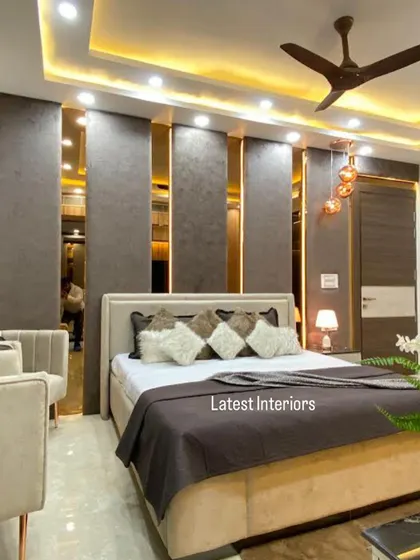 This angle highlights the bed's back wall, which features textured grey panels separated by vertical mirror strips. This design adds depth and a touch of glamour to the room.