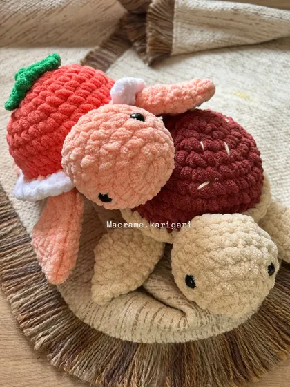 A close-up of two of our fruit-themed turtles. The soft, thick yarn makes them incredibly satisfying to squish and hold. Each one is handmade with care by our talented team.