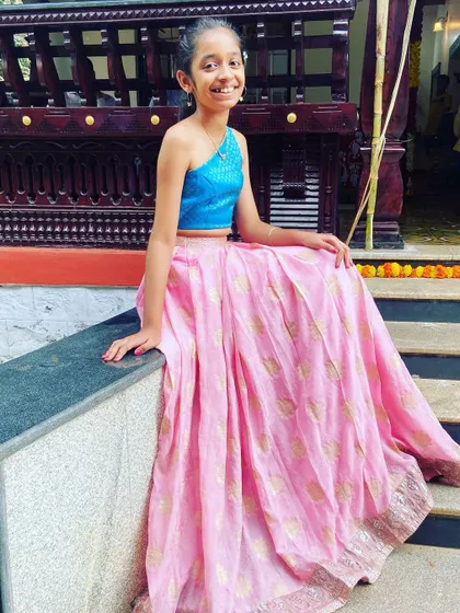 A closer look at this custom Indo-Western lehenga set, showing how the modern one-shoulder top sits beautifully. The combination of the bright blue top and the soft pink skirt makes for a cheerful and eye-catching ensemble.