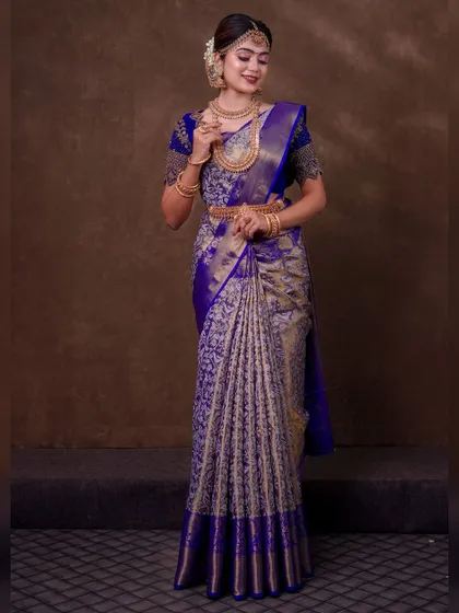 A royal blue and silver brocade saree. The draping here is all about showcasing the richness of the fabric, with a neatly pleated pallu and a full, grand silhouette.