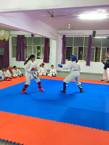 Two of our female students engage in a focused sparring match, demonstrating that karate builds confidence and skill in everyone, regardless of gender.