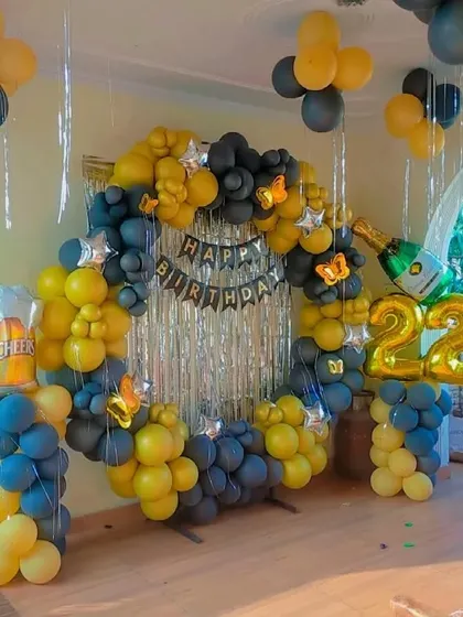 A 22nd birthday ring decoration in yellow and black, with a champagne bottle and beer mug foil balloon for a fun touch.