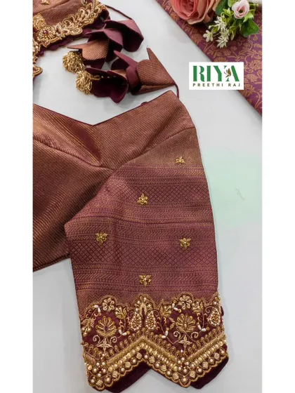 A close up of the sleeve of the brown Muhurtham blouse. You can see the detailed Zardosi work creating traditional motifs, finished with a border of delicate pearls. This level of craftsmanship is what makes a bridal blouse truly special.
