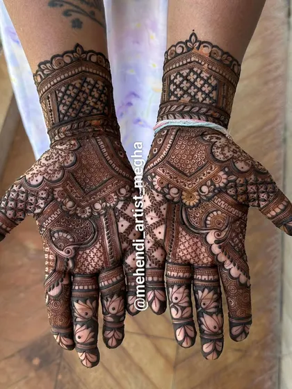 A gorgeous design where the palms are filled with intricate patterns and the fingers are adorned with delicate lotus buds. The wristband features a classic checkerboard pattern.