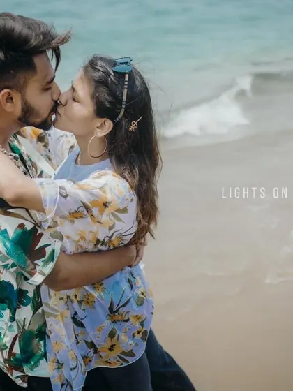 A candid shot of a couple sharing a kiss on the beach, capturing a spontaneous and joyful moment. We love documenting real affection during our beach pre-wedding sessions.
