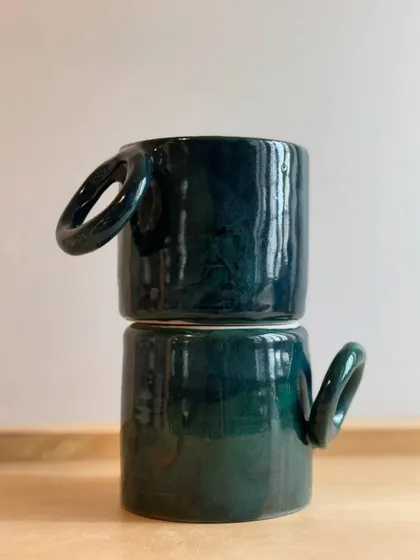 Two of the Forest Green mugs stacked, showing off their rich color and glossy finish.
