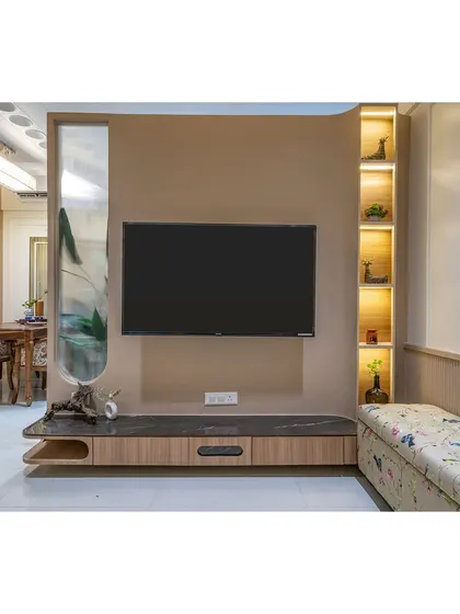 This TV unit features a unique design with a curved partition and an upholstered bench for extra seating, making it a multi-functional and stylish piece.