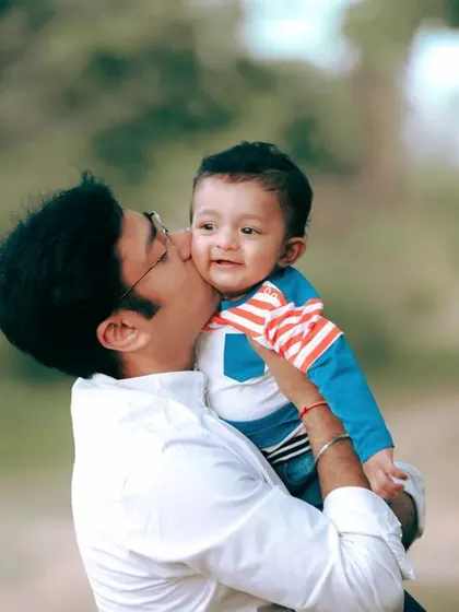 A father's gentle kiss for his son during their family portrait session, a small gesture that tells a big story.