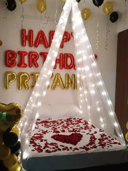 A close-up of the bed canopy with fairy lights and rose petals.