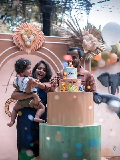 The cake-cutting ceremony at a boho 'Wild One' party. The family is surrounded by a beautifully crafted scene of friendly animals and earthy decorations.