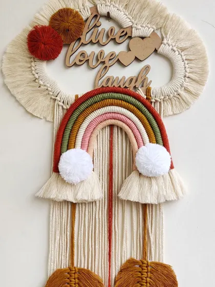 A full view of the custom "Live, Love, Laugh" macrame hanging, showing the wooden lettering and heart details at the top.