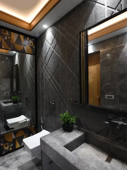 The guest bathroom in the Screen House is a striking blend of rough and polished stone, creating depth and elegance. Minimal engravings on the textured walls add subtle detail, enhancing the modern yet timeless appeal.