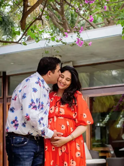Capturing the love story before the baby arrives. This tender moment under a bougainvillea tree adds a pop of color and a lot of warmth to their maternity album.