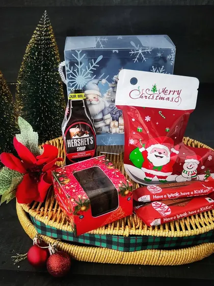 Our Christmas basket brings together chocolates, Hershey's chocolate syrup and a Santa mug, finished with festive ribbon and decorations.