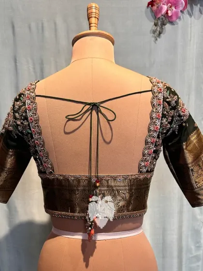 The back of the olive green blouse, finished with a stunning Dori and embellished tassels.