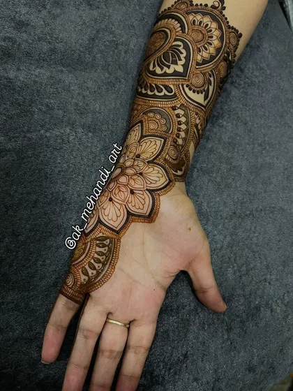 A close-up of the wrist and forearm portion of the design, showing the beautiful floral mandala work.